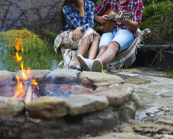 A fiatal pár gitár kint tűz közelében — Stock Fotó