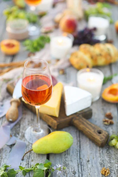 One glass of rose wine on table with fruits and cheese — Stock Photo, Image