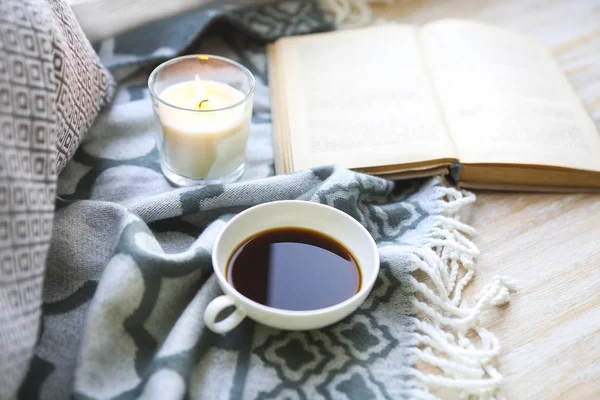 Kopp kaffe, ljus och bok på golvet — Stockfoto