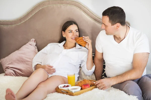Pregnant woman and man having breakfast with orange juice and cr — Stock Photo, Image