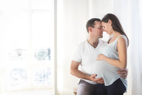 Pregnant woman and young man together indoors — Stock Photo, Image