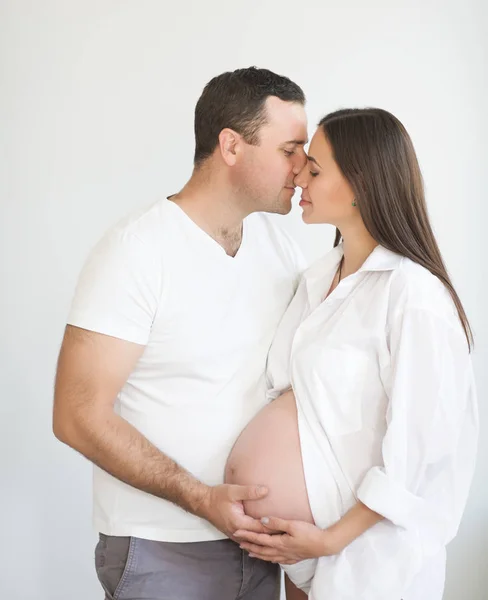 Zwangere vrouw en jonge man samen binnenshuis — Stockfoto