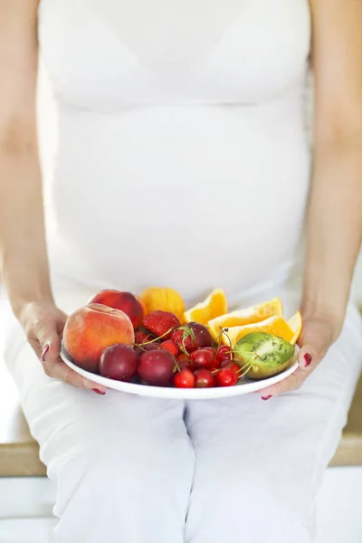Těhotná žena s ovocem na štítku — Stock fotografie