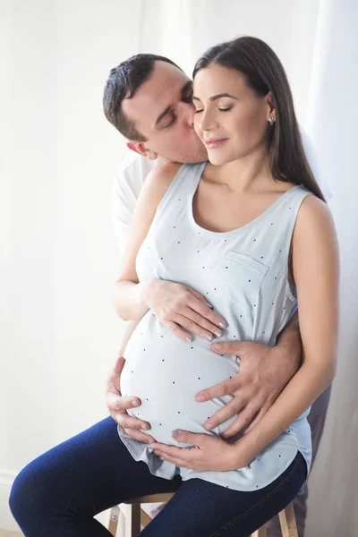 Pregnant woman and young man together indoors — Stock Photo, Image