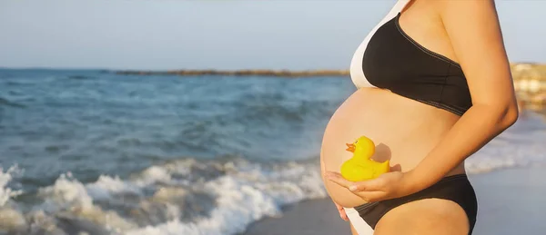 Молодая беременная женщина на пляже — стоковое фото