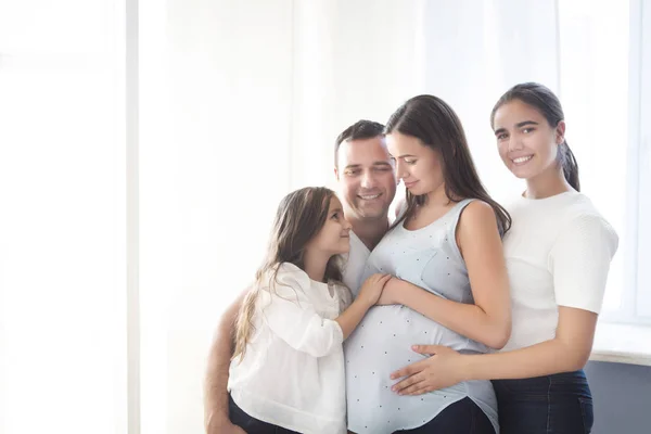 Mujer embarazada feliz con su marido y sus hijos — Foto de Stock