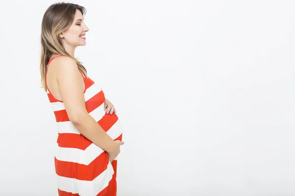 Mulher muito grávida dentro de casa no fundo branco — Fotografia de Stock