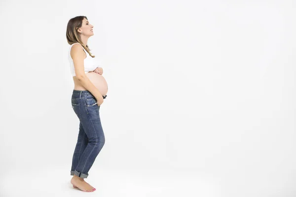 Velmi těhotná žena doma na bílém pozadí — Stock fotografie