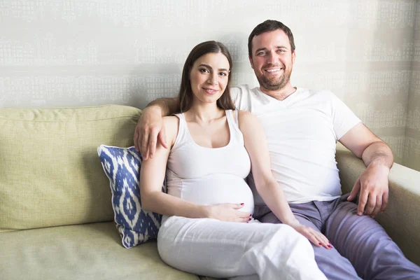 Pregnant woman and young man together indoors — Stock Photo, Image