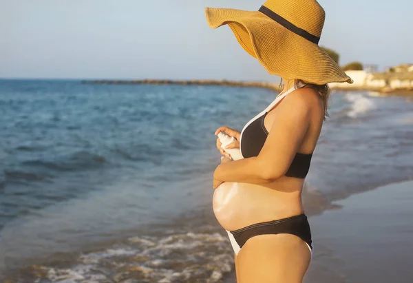 Mujer embarazada joven en la playa de verano — Foto de Stock
