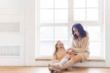 Sabah pencere yakınındaki küçük kız ile genç kadın