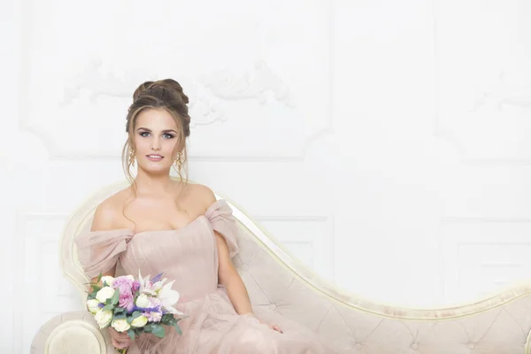 Young pretty bride with bridal bouquet indoors — Stock Photo, Image