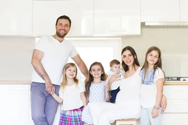 Adorable young big family embracing on kitchen — Stock Photo, Image