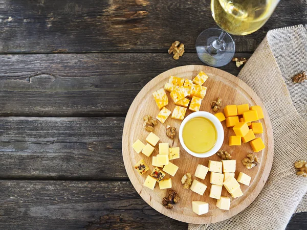 Set of different kind of cheeses with a glass of white wine on t — Stock Photo, Image