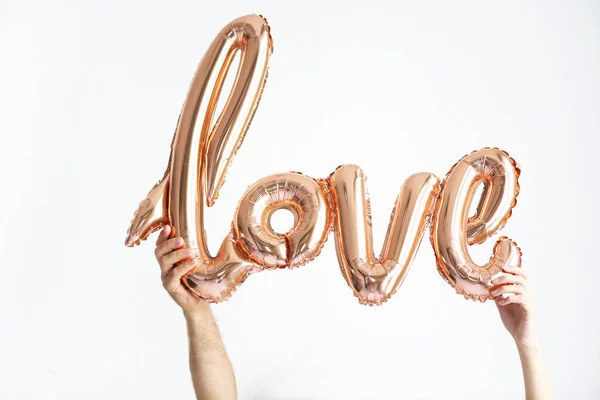 Пара с шаром в форме слова "Любовь" — стоковое фото
