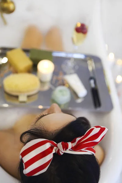 Attraktive Mädchen entspannen in der Badewanne auf hellem Hintergrund — Stockfoto