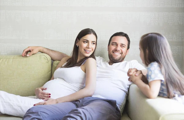 Красивая молодая беременная семья в гостиной — стоковое фото