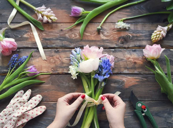 Флорист на роботі. Жінка робить букет з весняних квітів — стокове фото