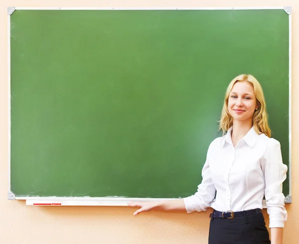 Estudante menina de pé perto de quadro negro na sala de aula — Fotografia de Stock