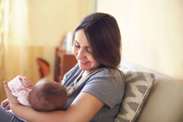 Jovem mãe segurando seu filho recém-nascido. Mãe bebê de enfermagem. — Fotografia de Stock