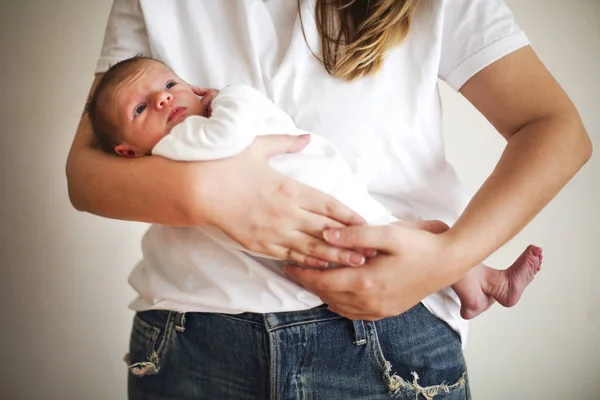 Ibu muda menggendong anaknya yang baru lahir. Ibu menyusui bayi. Keluarga — Stok Foto