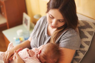 Yeni doğmuş çocuğunu tutan genç anne. Anne bakım bebek. Aile