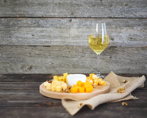 Набор различных видов сыров с бокалом белого вина — стоковое фото