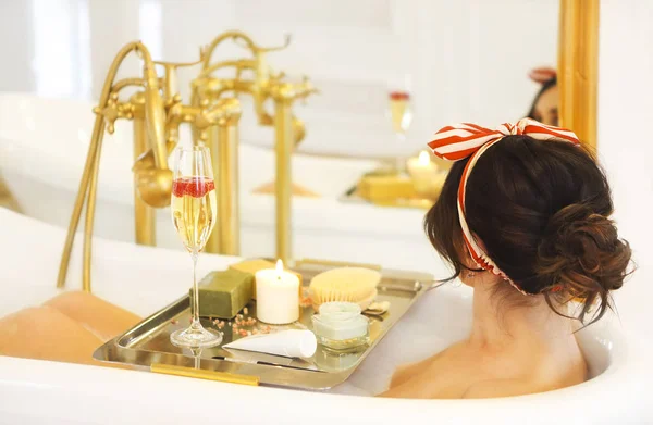 Привлекательная девушка расслабляется в ванне на светлом фоне — стоковое фото