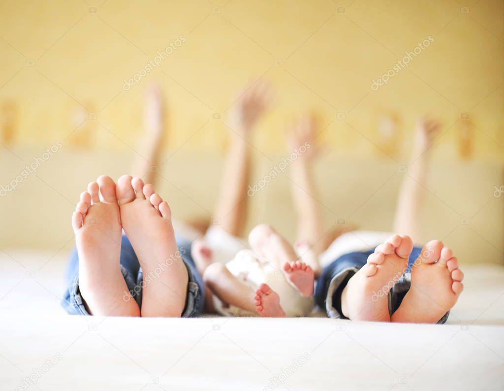 Sweet family in bed. Three sisters, close up on feet