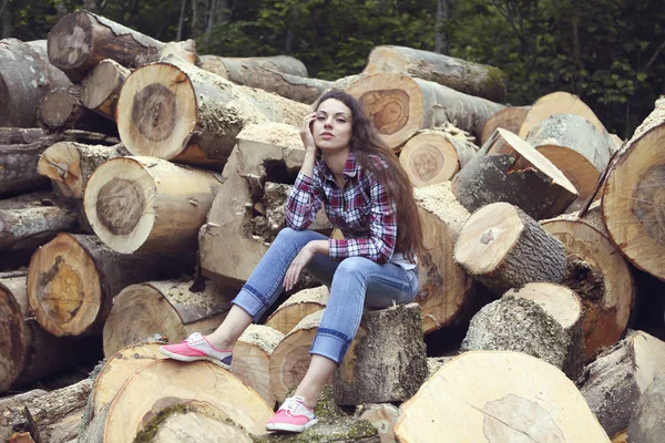Bella giovane donna di campagna su sfondo legna da ardere — Foto Stock