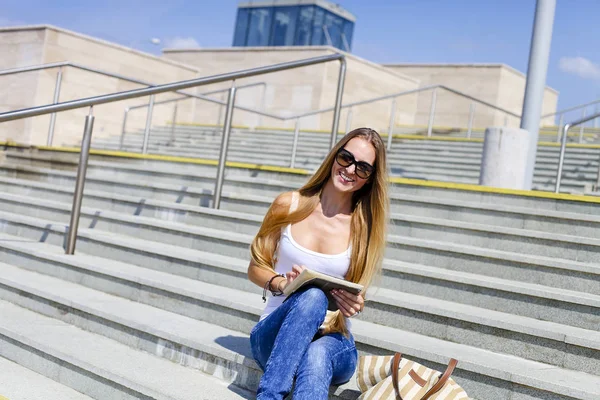 Jonge blonde vrouwelijke college student met behulp van tablet pc buiten — Stockfoto