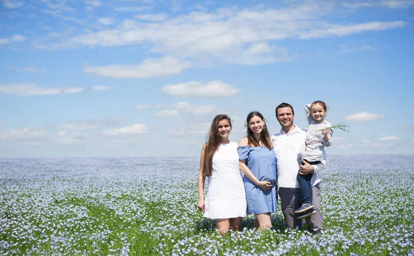Retrato de una joven familia embarazada en el campo de lino —  Fotos de Stock