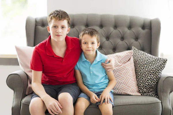 Older brother on the sofa hugging younger brother — Stock Photo, Image