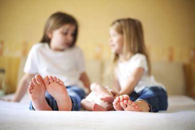 Sweet aile yatakta. Üç kız kardeş, ayakları üzerinde kapat