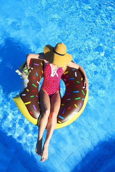 Ung kvinna på uppblåsbar madrass i poolen — Stockfoto