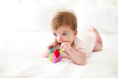 Altı aylık bebek yatağında oynarken 