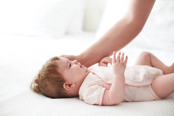Six month baby on bed playing with father — Stock Photo, Image