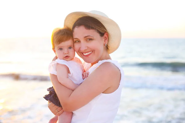 Jeune femme béatifique avec bébé sur la plage — Photo