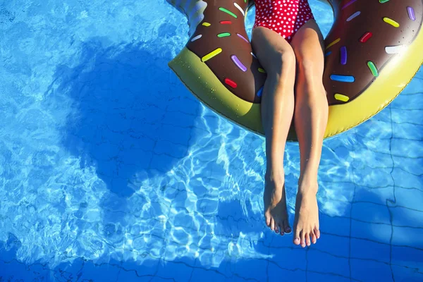 Mujer joven en colchón inflable en la piscina — Foto de Stock