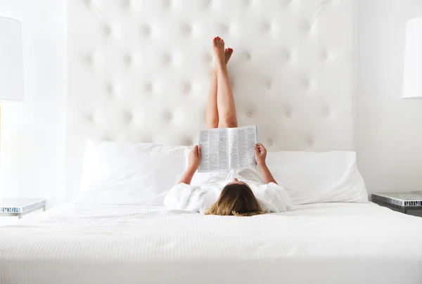 Happy woman reading a magazine in the bed — Stock Photo, Image