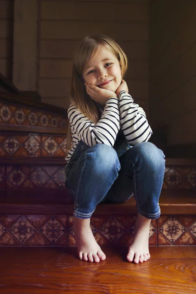 Feliz menina bonito sentado nas escadas — Fotografia de Stock