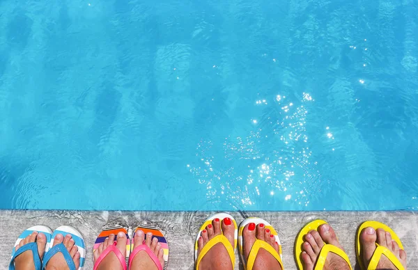 Pies en chanclas sobre fondo de piedra — Foto de Stock