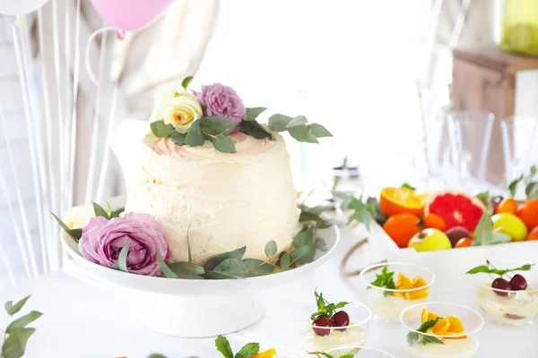 Vakantie taart op tafel met vruchten en bloemen — Stockfoto