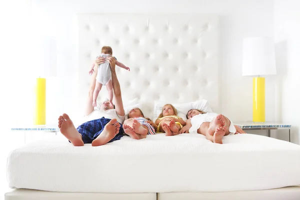 Lycklig familj med tre barn i sovrummet — Stockfoto