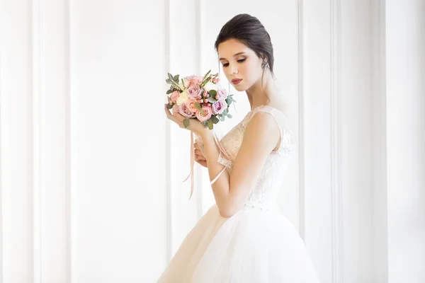 Joven hermosa morena con ramo posando en una boda —  Fotos de Stock