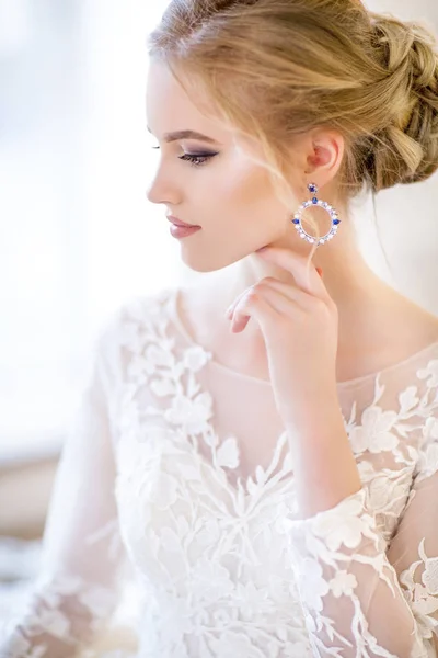 Junge schöne blonde Frau posiert in einem Hochzeitskleid — Stockfoto