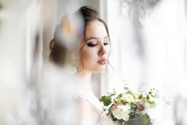 Bella donna bruna con bouquet in posa in un abito da sposa — Foto Stock