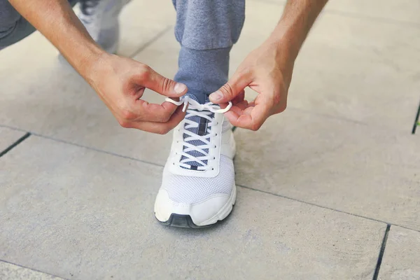 Man lacing running shoes before workout. Close up — Stock Photo, Image