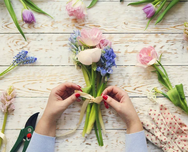 직장에서 플로리스트입니다. 봄 꽃의 꽃다발을 만드는 여자 — 스톡 사진