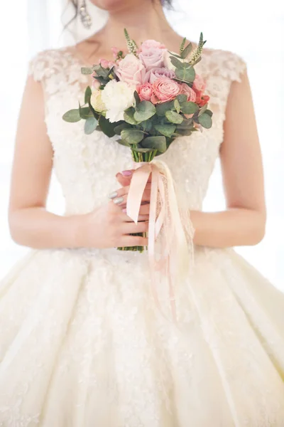 Молодая красивая брюнетка с букетом, позирующая на свадьбе — стоковое фото